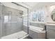 Modern bathroom featuring a glass-enclosed shower, soaking tub, and neutral tile at 11035 W Grand Pl, Littleton, CO 80127