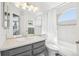 Bright bathroom with a soaking tub, shower, a large mirror, and stylish gray cabinets at 11035 W Grand Pl, Littleton, CO 80127