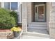 Inviting front entrance with a decorative brick column and planter filled with vibrant yellow flowers at 11035 W Grand Pl, Littleton, CO 80127