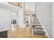 Bright foyer with hardwood floors, a staircase leading to the second floor, and a view of the dining area at 11035 W Grand Pl, Littleton, CO 80127