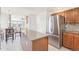 Modern kitchen features stainless steel refrigerator, granite counters, kitchen island, and tile floors at 11035 W Grand Pl, Littleton, CO 80127