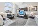 Bright living room with a large window, plush carpet, comfortable seating, and a modern entertainment center at 11035 W Grand Pl, Littleton, CO 80127