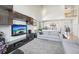 Spacious living room with high ceilings, modern entertainment center, and view of the adjacent dining area at 11035 W Grand Pl, Littleton, CO 80127