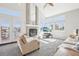 Sunlit living room features vaulted ceilings, brick fireplace, many windows, and comfortable seating at 11035 W Grand Pl, Littleton, CO 80127