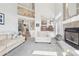 Spacious living room with fireplace, many windows, vaulted ceilings, and stairs to second floor at 11035 W Grand Pl, Littleton, CO 80127