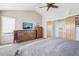 Bright main bedroom featuring wood furniture, a ceiling fan, neutral paint, and an ensuite bathroom at 11035 W Grand Pl, Littleton, CO 80127