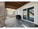 Basement patio with stone floor and sliding glass door at 1171 E Hopkins Dr, Elizabeth, CO 80107