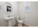 Small powder room with pedestal sink and toilet at 1171 E Hopkins Dr, Elizabeth, CO 80107