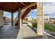 View of the covered patio and stone columns with artificial turf yard at 1171 E Hopkins Dr, Elizabeth, CO 80107