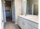 Bright bathroom featuring a double sink vanity, a large mirror, and tile floors; closet space is visible in the background at 8945 Rifle St, Commerce City, CO 80022