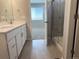 Modern bathroom featuring a double vanity, a glass-enclosed shower, and a view into the adjacent bedroom at 8945 Rifle St, Commerce City, CO 80022