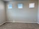 Cozy carpeted bedroom with three windows providing natural light and ventilation at 8945 Rifle St, Commerce City, CO 80022