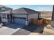 Charming single-Gathering home with a gray exterior, a gray garage door, and stone accents at 8945 Rifle St, Commerce City, CO 80022