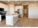 Bright kitchen features stainless steel appliances, a large island, and white cabinets at 8945 Rifle St, Commerce City, CO 80022