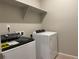 Modern laundry room with white washer and dryer, featuring overhead shelf and clean, bright aesthetic at 8945 Rifle St, Commerce City, CO 80022