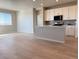 Open-concept kitchen and living room with stainless steel appliances and light wood floors at 8945 Rifle St, Commerce City, CO 80022