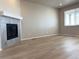 Neutral living room featuring fireplace, gray tile surround, and a large window for ample natural light at 8945 Rifle St, Commerce City, CO 80022