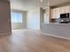 Living room and kitchen area boast hardwood floors and large windows with blinds at 8945 Rifle St, Commerce City, CO 80022