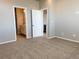 Carpeted main bedroom featuring doorways to the bathroom and kitchen area at 8945 Rifle St, Commerce City, CO 80022