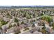 Aerial view of a suburban neighborhood with mature trees and a distant city skyline at 5459 E Dry Creek Cir, Centennial, CO 80122