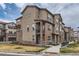 Attractive townhome showing a street view with manicured landscaping and stone pillar accents at 2225 Santini Trl # A, Littleton, CO 80129