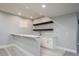 Basement wet bar with white cabinets and floating shelves at 3050 S Ash St, Denver, CO 80222