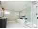 Luxurious bathroom with soaking tub, glass shower, and marble floors at 3050 S Ash St, Denver, CO 80222