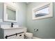 Small bathroom with white vanity and fixtures, and a window at 3050 S Ash St, Denver, CO 80222