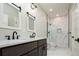 Bathroom with dark vanity, marble shower, and double sinks at 3050 S Ash St, Denver, CO 80222