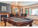 Bar area with wooden bar, wine rack and chairs near pool table in spacious finished basement at 2587 S Harlan Ct, Lakewood, CO 80227