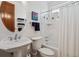 Bright bathroom featuring marble tile, shower-tub, modern fixtures, and a pedestal sink at 2587 S Harlan Ct, Lakewood, CO 80227