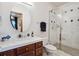 Updated bathroom featuring a tiled shower with glass door, a vanity, and modern fixtures at 2587 S Harlan Ct, Lakewood, CO 80227
