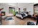 Primary bedroom featuring a fireplace, a chandelier, hardwood floors, large windows and a comfortable bed at 2587 S Harlan Ct, Lakewood, CO 80227
