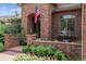 Close-up of the brick porch adorned with flowers, plants, and seating, creating a cozy entrance at 2587 S Harlan Ct, Lakewood, CO 80227