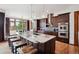 Spacious kitchen featuring an island with marble countertop, wooden cabinets, stainless steel ovens, and hardwood floors at 2587 S Harlan Ct, Lakewood, CO 80227