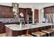Spacious kitchen with a marble countertop island, wooden cabinets, stainless steel ovens, and mosaic backsplash at 2587 S Harlan Ct, Lakewood, CO 80227
