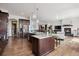 Open kitchen with stainless steel appliances, a marble countertop island, hardwood floors, and an adjoining living room at 2587 S Harlan Ct, Lakewood, CO 80227