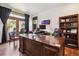 Office with a large wooden desk, hardwood floors, an ergonomic chair, a bookcase and access to the patio at 2587 S Harlan Ct, Lakewood, CO 80227