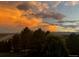 Picturesque sunset view over mature trees and the front yard; a breathtaking backdrop to this property at 2587 S Harlan Ct, Lakewood, CO 80227