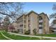 Multi-story building with a brick facade, surrounded by trees and green space, offering a serene living environment at 3144 S Wheeling Way # 401, Aurora, CO 80014