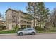 Apartment building with covered patios, lush landscaping, and a silver SUV parked nearby at 3144 S Wheeling Way # 401, Aurora, CO 80014
