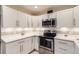 Bright kitchen features white cabinetry, stainless steel appliances, and modern countertops at 3144 S Wheeling Way # 401, Aurora, CO 80014