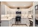 Bright kitchen features white cabinets, stainless steel appliances, and under-cabinet lighting at 3144 S Wheeling Way # 401, Aurora, CO 80014