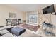 Cozy living room features a gray sofa, an ottoman, barstools, a colorful rug, and a view of balcony at 3144 S Wheeling Way # 401, Aurora, CO 80014