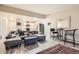 Spacious living room with kitchen view, featuring gray sofa, ottoman, barstools, and wood-look flooring at 3144 S Wheeling Way # 401, Aurora, CO 80014