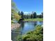 Scenic view of a pond surrounded by lush greenery and trees, reflecting the clear blue sky at 3144 S Wheeling Way # 401, Aurora, CO 80014