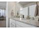 Bathroom features a double sink vanity with white cabinets, granite countertops, and modern fixtures at 8075 S Vandriver Way, Aurora, CO 80016