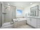 Elegant bathroom features a separate shower and soaking tub beneath a window offering natural light at 8075 S Vandriver Way, Aurora, CO 80016