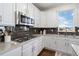 Stylish kitchen showcasing granite countertops, a gas range, stainless steel microwave and dark backsplash at 8075 S Vandriver Way, Aurora, CO 80016
