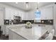 Modern kitchen with white cabinetry, granite countertops, stainless steel appliances, and stylish pendant lighting at 8075 S Vandriver Way, Aurora, CO 80016